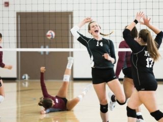 With the best indoor volleyball shoes, girls are happy after the goal of the opponent team on the indoor volleyball court