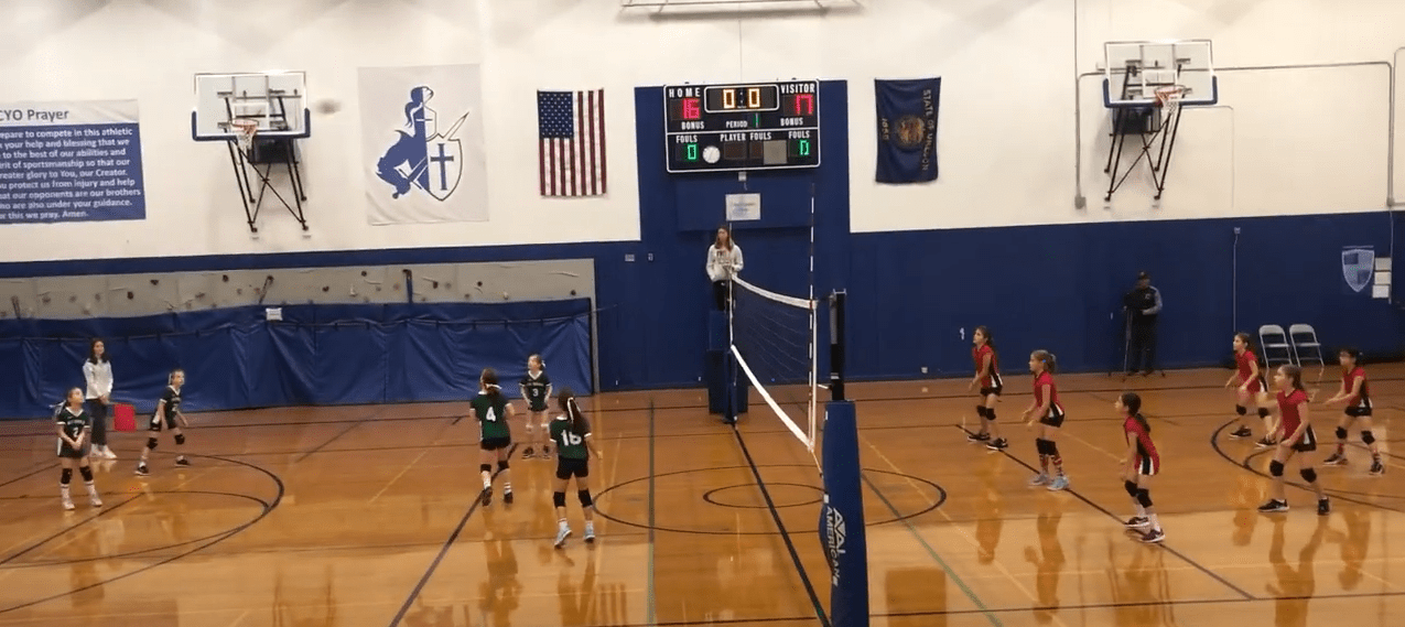 kids playing volleyball in an indoor court