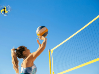 A women playing volleyball on outdoor court