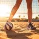 Men playing volleyball in the sand in the afternoon, wearing EVA midsole volleyball shoes for enhanced comfort and performance