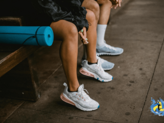 boys and girls sitting on a table wearing white sports shoes for volleyball