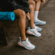 boys and girls sitting on a table wearing white sports shoes for volleyball