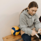 a girl sitting in indoor volleyball court with a volleyball in her side