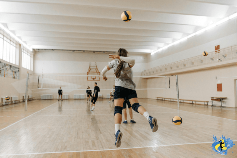 A girl trying to hit the volleyball for opponent on indoor volleyball court