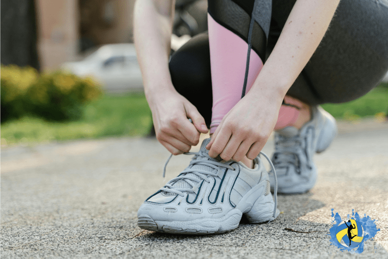 a girl tighting her running shoe laces